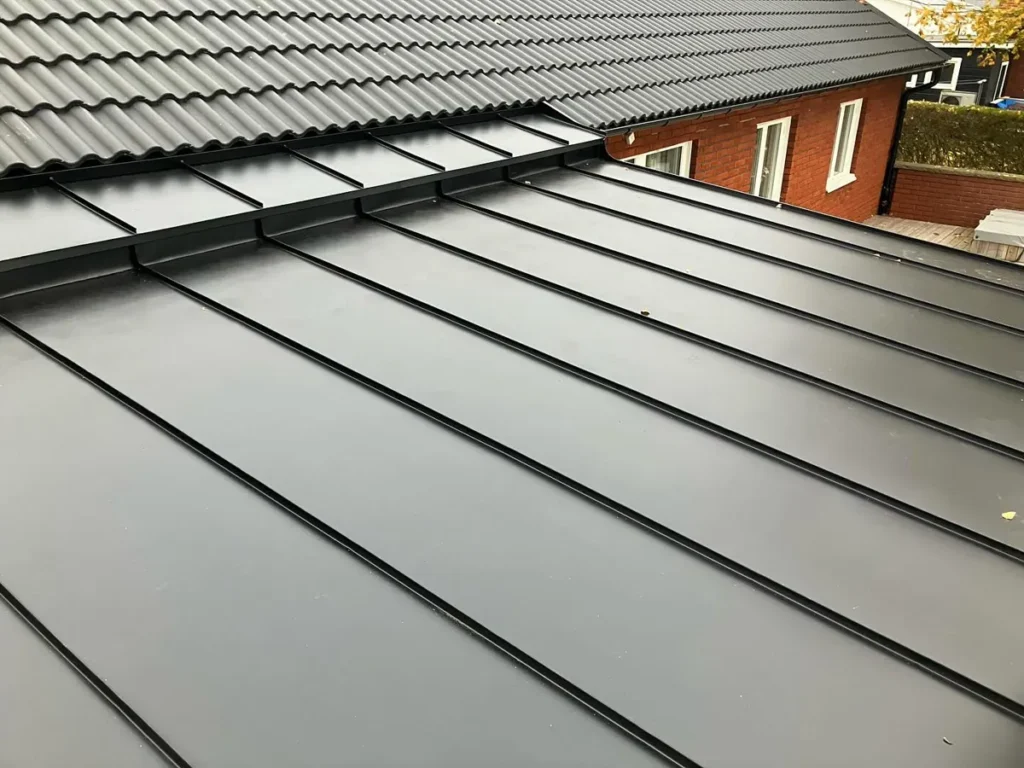 Svart bandtäckning i anslutning till betongpannor på ett villatak